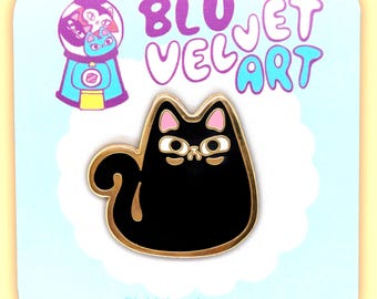 May include: Black enamel cat pin with gold outline and pink ears. The pin is on a blue and white background with the text "BluVelvetArt.com".