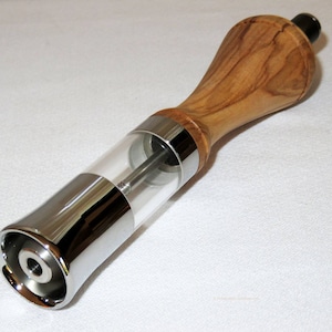 May include: A wooden and chrome pepper mill with a clear acrylic grinding chamber. The mill is designed to grind peppercorns.