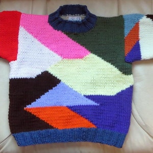 May include: A colorful knitted sweater with a geometric pattern in shades of blue, pink, white, red, orange, green, and brown.
