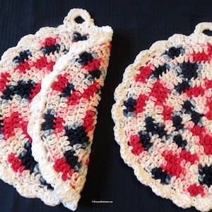 May include: Two crocheted pot holders with a white border and a center design of red, pink, black, and gray yarn. Each pot holder has a loop for hanging.