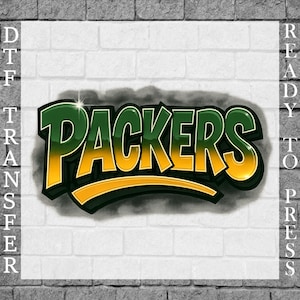 May include: A DTF (Direct to Film) transfer design featuring the word "Packers" in a bold, stylized font. The text is in green and yellow with a black outline, set against a white background with a brick wall texture.