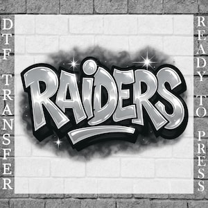 Könnte beinhalten: Silbernes und schwarzes "Raiders"-Grafikdesign mit Schatteneffekt und Sternen-Akzenten. Das Design befindet sich vor einem weißen Hintergrund mit dem Text "DTF TRANSFER" links und "READY TO PRESS" rechts. Der Hintergrund ist eine Backsteinmauer.