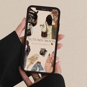 Peut inclure: Un smartphone affiche un collage sur le thème de l'automne avec le texte "AUTUMN MOOD" et "bymarinatemplates". Le collage comprend des images d'une femme en manteau, de café et d'accessoires de mode. Le téléphone est tenu par une personne portant un blazer noir.