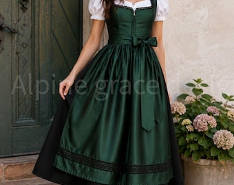 May include: A dark green dirndl dress featuring a white blouse with short puff sleeves, a fitted bodice with a front zipper, and a full skirt with a black lace trim at the hem. A matching green fabric tie is fastened at the waist in a bow.