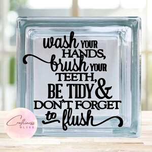May include: A glass block with a black vinyl decal that reads "Wash your hands, brush your teeth, be tidy & don't forget to flush".