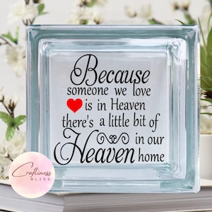 May include: A glass block with the text "Because someone we love is in Heaven there's a little bit of Heaven in our home" and a red heart.
