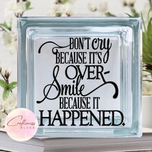 May include: A glass block with the text "Don't cry because it's over-Smile because it happened." printed in black.