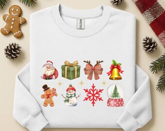Könnte beinhalten: Weißes Sweatshirt mit weihnachtlichen Grafiken. Das Design umfasst den Weihnachtsmann, ein Geschenk, eine Schleife mit Geweih, eine Glocke, einen Lebkuchenmann, einen Schneemann, einen Schneeflocke und eine Schneekugel. Festliche Kleidung.
