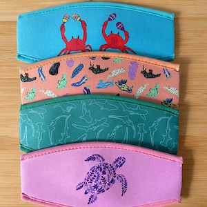 May include: A white ceramic mug with a black handle and the text "But First, Coffee" in a black, bold font. The mug is on a white surface.