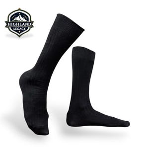May include: Two black ribbed socks, one angled and the other upright, are displayed against a white background. The socks are knee-high and have a textured, vertical ribbed pattern. The Highland Legacy logo is in the upper left corner.