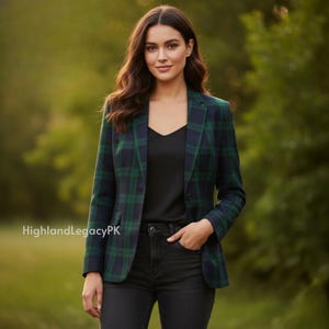 May include: A green and navy plaid blazer with a two-button closure. The blazer is worn over a black top and paired with black jeans. The image includes the text "HighlandLegacyPK".