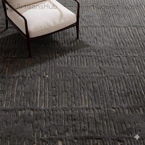 May include: A dark gray area rug with a textured, linear pattern. The rug is made of a soft material and has a neutral color palette. A white armchair with a dark brown frame is in the upper left corner. The rug is suitable for living rooms and bedrooms.