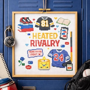 May include: A framed cross-stitch piece with a sports theme, featuring a black and gold jersey with the number 81, a blue jersey with the number 24, and the words "HEATED RIVALRY". Other elements include a football, a book, and a phone.