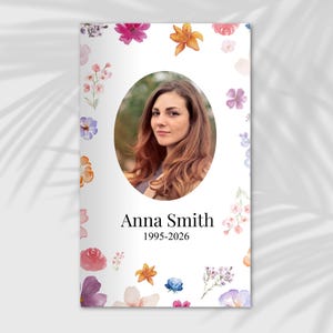 Pode incluir: Um cartão de memória com um retrato de uma mulher em uma moldura oval, cercado por ilustrações florais em aquarela em tons de rosa, roxo, laranja e azul. O nome "Anna Smith" e os anos "1995-2026" são impressos abaixo.