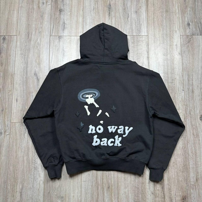 Może przedstawiać: Czarna bluza z kapturem z grafiką na plecach przedstawiającą UFO, postać i biały napis "no way back". Bluza posiada kaptur ze sznurkiem oraz prążkowane mankiety i d&oacute;ł.
