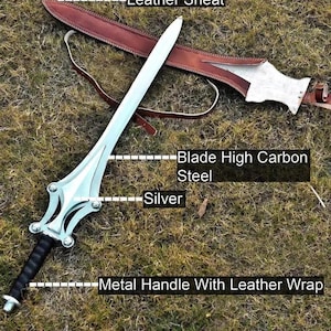 Op de afbeelding: Een zilveren zwaard met een lemmet van hoog koolstofstaal en een metalen handvat met leer omwikkeld. Het zwaard wordt getoond met een bruine leren schede. De tekst op de afbeelding luidt: "Blade High Carbon Steel", "Silver" en "Metal Handle With Leather Wrap".