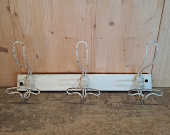 Vintage coat rack with decorative hooks.
