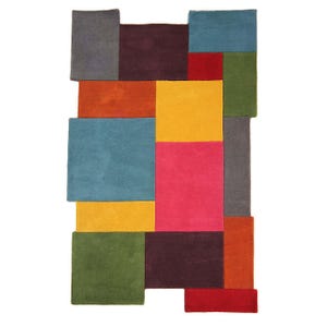 Puede incluir: Una alfombra rectangular con un patrón geométrico de bloques de colores sólidos en tonos verde azulado, amarillo mostaza, magenta, verde oliva, morado oscuro, naranja, rojo y gris carbón, dispuestos en una cuadrícula asimétrica.