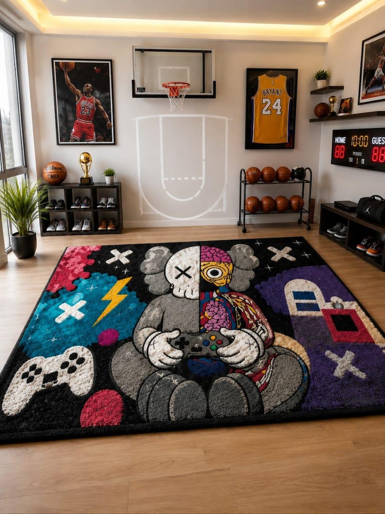 Puede incluir: Una alfombra rectangular que presenta un personaje de dise&ntilde;o dividido sosteniendo un mando de videojuegos. El personaje es mitad gris y mitad anat&oacute;mico con cerebro y tejido muscular expuestos. El fondo incluye un mando blanco, un rayo amarillo y formas abstractas coloridas sobre un campo negro.