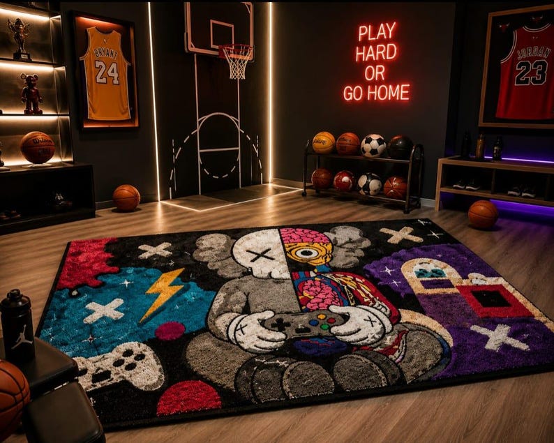 Puede incluir: Una alfombra rectangular con un personaje de dise&ntilde;o dividido que sostiene un mando de juego. Un lado muestra una figura esquel&eacute;tica gris con un ojo en forma de X, mientras que el otro revela un cerebro anat&oacute;mico colorido. Incluye motivos de rayos y X.