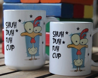 Puede incluir: Dos tazas de cerámica blanca con un diseño de gallina de dibujos animados. Las tazas tienen el texto "SHUH DUH FUH CUP" y una gallina de dibujos animados con cresta roja, pico amarillo y fondo azul. Las tazas están sobre una superficie de madera.