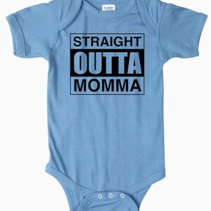 May include: A light blue baby onesie with a black graphic that says "STRAIGHT OUTTA MOMMA".