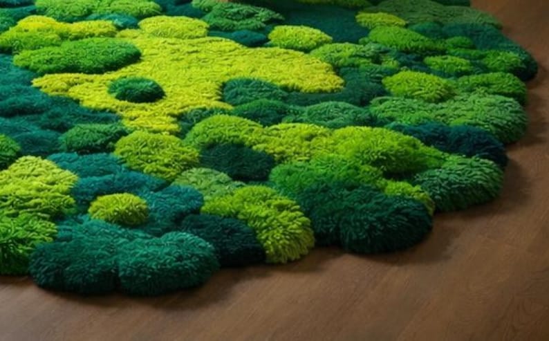 May include: A vibrant, textured rug in shades of green, resembling a mossy landscape. The rug features a variety of green hues, from deep emerald to bright lime, creating a natural, organic aesthetic. The rug's design is reminiscent of a forest floor.
