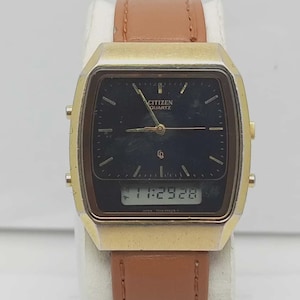 May include: A vintage Citizen Quartz watch with a gold-tone rectangular case and a brown leather strap. The watch face is black with analog hands and a digital display showing the time. The watch has a classic, retro design.