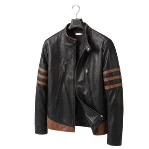 May include: A black jacket with a stand-up collar, featuring three horizontal brown stripes on each sleeve and a brown panel along the bottom hem. The jacket includes a front zip fastening, two diagonal zipped chest pockets, and a snap button.