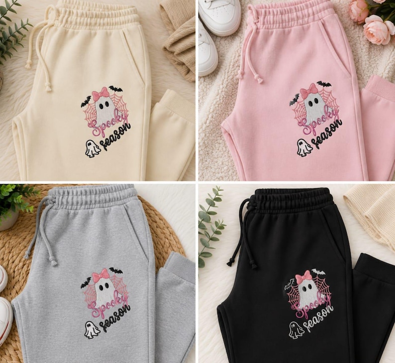 May include: Four pairs of sweatpants in cream, light pink, heather gray, and black. Each pair features an embroidered graphic of a ghost with a pink bow, a spiderweb, bats, and the text Spooky season in black and pink script lettering.
