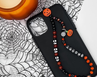 Correa para teléfono de temporada de Halloween – Negra, con cuentas de vidrio naranja y dijes de Halloween