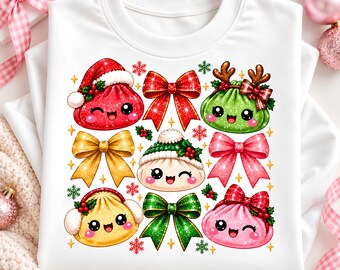 May include: A white sweatshirt featuring a graphic print of various colorful, smiling dumpling characters wearing holiday accessories like Santa hats, reindeer antlers, and earmuffs, interspersed with glittery bows and snowflakes.