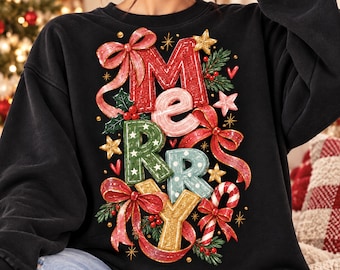 May include: A black long-sleeve sweatshirt featuring a colorful graphic print of the word MERRY. The letters are decorated with festive elements including red ribbons, green holly leaves, small white stars, polka dots, and candy cane stripes.