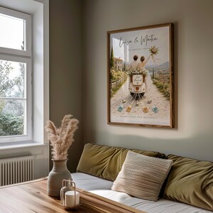 May include: A framed wall art print featuring a couple on a scooter with the text Luiza & Martin, 20. AUGUST 2024, Just Married, and ALLES LIEBE ZUR HOCHZEIT. The illustration shows a scenic path, a stone building, and hanging currency notes.