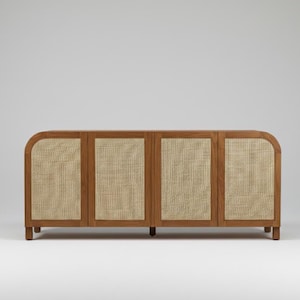 May include: A wooden cabinet with four doors. The doors have a woven cane center and a rounded top. The cabinet is made of light brown wood and has a simple, modern design. The cabinet is a storage unit.