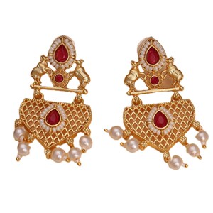Peut inclure: Boucles d'oreilles dorées avec un motif en filigrane. Chaque boucle d'oreille présente une pierre rouge en forme de goutte, entourée de petites perles blanches. Des pierres rouges supplémentaires et des perles pendantes complètent le design. Les boucles d'oreilles ont un dessus décoratif avec deux petites figurines d'animaux.