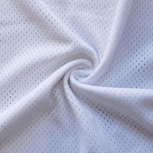 a close-up view of a white fabric with a perforated pattern, likely a type of athletic or sportswear material.
