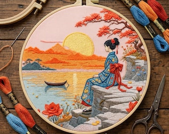 Op de afbeelding: Geborduurd kunstwerk in een cirkel, met een Japanse scène met een vrouw in kimono, een zonsondergang, bergen en een boot. Het kleurenschema omvat oranje, geel, blauw en roze. Borduurgaren en gereedschap omringen het werk. De cirkel heeft een diameter van ongeveer 20 cm.