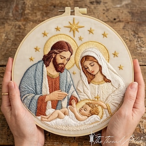 Puede incluir: Un bastidor de bordado circular con una representación detallada de la Sagrada Familia. El diseño muestra una figura barbuda con túnica azul, una figura con velo blanco y un bebé, todos con halos dorados y rodeados de estrellas bordadas.