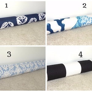 May include: Four different doorstop designs. The first doorstop has a blue and white pattern with lobsters. The second doorstop has a blue and white pattern with a seahorse design. The third doorstop has a blue and white damask pattern. The fourth doorstop has a black and white striped pattern.