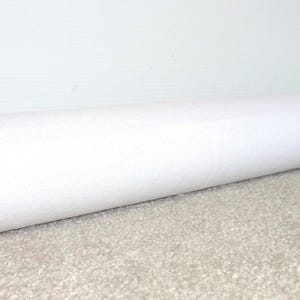May include: White door draft stopper, a long, cylindrical tube made of fabric, placed at the bottom of a door to prevent drafts.