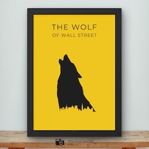 Puede incluir: Un póster enmarcado con borde negro presenta un fondo amarillo y una silueta negra de un lobo aullando sobre un paisaje urbano. El texto "THE WOLF OF WALL STREET" está en la parte superior.