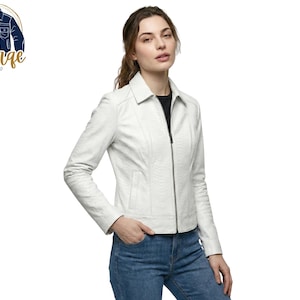 Puede incluir: Una chaqueta blanca texturizada con cuello clásico, mangas largas y cierre de cremallera frontal completo. La chaqueta presenta un sutil patrón en relieve en toda la superficie, costuras estructuradas y dos bolsillos laterales, combinada con pantalones vaqueros azules.