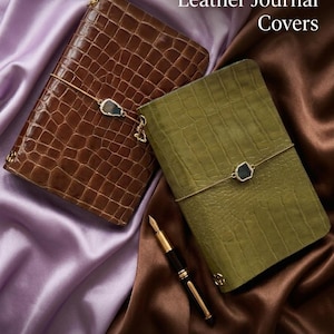 Puede incluir: Dos cubiertas de diario de cuero repujado de cocodrilo, marrón y verde oliva, con una pluma dorada. Los diarios tienen un cierre de piedra decorativo y un cierre elástico dorado. El texto dice "Croc Embossed Leather Journal Covers" y "handmade - stylish look - genuine leather."
