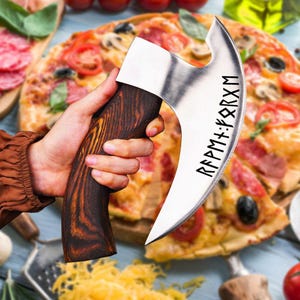 May include: A pizza cutter with a curved stainless steel blade and a dark wood handle. The blade has etched runes. The cutter is held in front of a pizza with tomatoes, mushrooms, and pepperoni.
