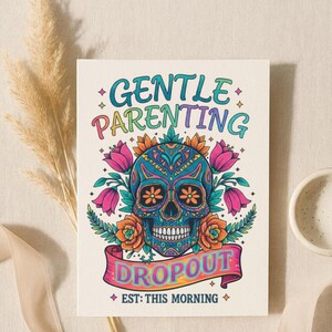 K&ouml;nnte beinhalten: Eine farbenfrohe Karte mit einem Totenkopf-Design, umgeben von Blumen und dem Text "GENTLE PARENTING DROPOUT" in Regenbogenfarben. Der Satz "EST: THIS MORNING" ist ebenfalls enthalten. Der Hintergrund ist cremefarben.