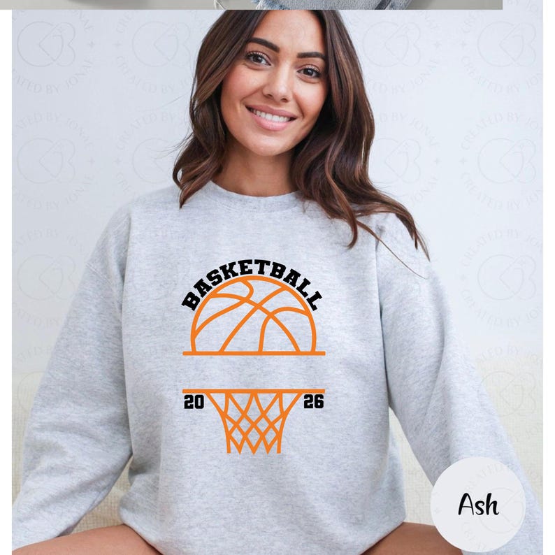 Pu&ograve; includere: Felpa grigio chiaro con grafica di basket. La grafica include la parola "BASKETBALL" sopra un disegno di pallone da basket, con i numeri "20" e "26" ai lati di un canestro. La felpa &egrave; realizzata in materiale morbido.