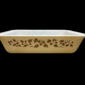 May include: Rectangular baking dish with a cream-colored exterior and a brown leaf and vine pattern. The interior is white. The dish has a simple, classic design, suitable for baking and serving.