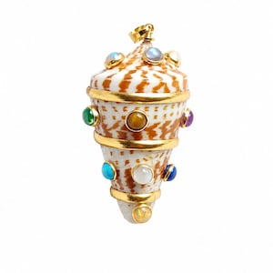 Op de afbeelding: Een kegelvormige schelphanger met een bruin en wit patroon op het oppervlak, geaccentueerd met drie horizontale goudkleurige metalen banden en meerdere ronde, kleurrijke cabochon edelstenen ingebed rond de buitenkant, bekroond met een gouden oogje.