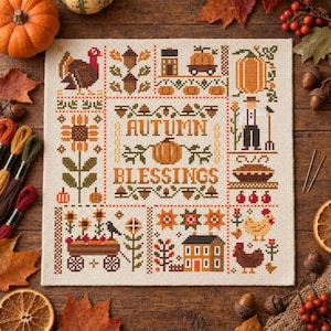 May include: A square cross-stitch sampler on cream fabric featuring the text Autumn Blessings in the center. The design includes motifs of a turkey, pumpkins, sunflowers, a house, a scarecrow, a wagon, and chickens in a grid layout with fall colors.